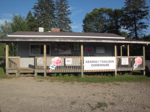 Exterior of Kearney Trailside Cookhouse. There is a wooden deck with signage.